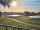 Picturesque view of a serene golf course with a pond reflecting the sunlight and blue sky at 7240 Westpointe Blvd # 1122, Orlando, FL 32835