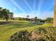 Scenic golf course view featuring lush green fairways, mature trees, and a bright blue sky with clouds at 7240 Westpointe Blvd # 1122, Orlando, FL 32835