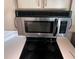 Close-up of a stainless steel microwave and a flat top electric range, complemented by light wood cabinets at 7240 Westpointe Blvd # 1122, Orlando, FL 32835