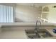 Bright kitchen featuring a stainless steel sink, laminate countertops, and open view to the living room at 7240 Westpointe Blvd # 1122, Orlando, FL 32835