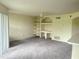 Spacious living room with neutral walls, gray carpet, a ceiling fan, and a wall of built-in shelves at 7240 Westpointe Blvd # 1122, Orlando, FL 32835