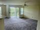Bright living room with neutral walls, ceiling fan, sliding glass door leading to a balcony, and plush carpeting at 7240 Westpointe Blvd # 1122, Orlando, FL 32835