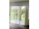 Close up of the patio door with vertical blinds and a balcony with railing, overlooking the green space at 7240 Westpointe Blvd # 1122, Orlando, FL 32835
