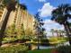Beautiful condo building with lush landscaping, serene pond, and charming pirate ship feature at 8125 Resort Village Dr # 5310, Orlando, FL 32821