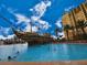 Fun pool with a pirate ship and multi-story building in the background, under a clear blue sky with fluffy clouds at 8125 Resort Village Dr # 5310, Orlando, FL 32821