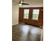 Inviting bedroom featuring wood-look floors, ceiling fan, and natural light from the windows at 911 N Orange Ave # 142, Orlando, FL 32801