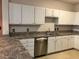 Bright kitchen featuring white cabinets, stainless steel dishwasher, and stone-look countertops at 911 N Orange Ave # 142, Orlando, FL 32801