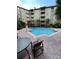 Community pool surrounded by lounge chairs and palm trees at 911 N Orange Ave # 142, Orlando, FL 32801