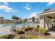 Community pool with lounge chairs and a covered seating area, surrounded by lush landscaping and palm trees at 916 Grandin St, Davenport, FL 33837