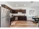 A view of the kitchen with stainless steel appliances and dark brown cabinets, next to a dining table at 916 Grandin St, Davenport, FL 33837