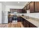 Kitchen with stainless steel appliances, granite countertops, and dark brown cabinets at 916 Grandin St, Davenport, FL 33837