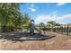 Community playground with slides, climbing structure, and protective surface surrounded by a black metal fence at 916 Grandin St, Davenport, FL 33837