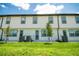 Townhouse exterior with well-maintained lawn, AC units, and young trees at 947 Conch Rd, Davenport, FL 33896