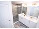 Modern bathroom featuring double sinks, quartz counters, updated hardware, and a glass-enclosed shower at 947 Conch Rd, Davenport, FL 33896