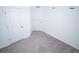 A bright bedroom featuring neutral carpeting and crisp white walls with two doors at 947 Conch Rd, Davenport, FL 33896