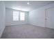 A spacious bedroom with neutral carpeting and ample natural light from two windows at 947 Conch Rd, Davenport, FL 33896