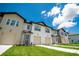 New construction townhomes featuring neat landscaping, attached garages and a bright blue sky at 947 Conch Rd, Davenport, FL 33896