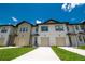 Beautiful townhomes showcasing modern architecture, complemented by lush green lawns and blue skies at 947 Conch Rd, Davenport, FL 33896