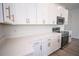 Modern kitchen featuring white cabinets, quartz countertops, stainless steel appliances, and stylish hardware at 947 Conch Rd, Davenport, FL 33896