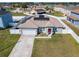 Aerial view of a single-story home featuring solar panels, a two-car garage, a manicured lawn, and a fenced yard at 152 Big Black Dr, Kissimmee, FL 34759