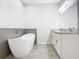 Bright bathroom featuring a standalone tub, granite countertops and white cabinets at 152 Big Black Dr, Kissimmee, FL 34759