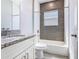 Bathroom with granite countertops, white cabinets, shower and grey tile accent wall at 152 Big Black Dr, Kissimmee, FL 34759