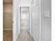 Hallway with wood-style floors, gray walls, and white doors leading to the bathroom and other rooms at 152 Big Black Dr, Kissimmee, FL 34759