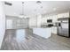 Modern kitchen featuring stainless steel appliances, granite countertops, white cabinets, a kitchen island, and wood-style flooring at 152 Big Black Dr, Kissimmee, FL 34759