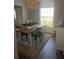 Inviting dining area with wood table, woven pendant light, and abundant natural light from the large window at 11115 Sw 54Th Cir, Ocala, FL 34476