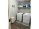A laundry room with a washer, dryer, shelving, and laundry themed decor at 11115 Sw 54Th Cir, Ocala, FL 34476