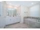 Bright bathroom with double vanity, marble countertops, and a large soaking tub at 1137 Drop Ln # 1137, Davenport, FL 33896