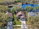 Stunning aerial perspective of lakeside home with green lawns, and access to a tranquil pond at 13223 Meadowlark Ln, Orlando, FL 32828