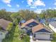 Beautiful aerial shot of a blue home with a well-manicured lawn, mature trees, and a two-car garage at 13223 Meadowlark Ln, Orlando, FL 32828