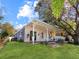 Rear of the house showcasing a covered patio, manicured lawn, and a fenced yard for privacy at 13223 Meadowlark Ln, Orlando, FL 32828