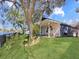 Lush backyard with a covered patio, mature shade trees and scenic lake view at 13223 Meadowlark Ln, Orlando, FL 32828