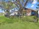 Large backyard with a well-maintained lawn, patio, mature trees, and a black metal fence at 13223 Meadowlark Ln, Orlando, FL 32828