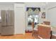 Cozy dining area with wicker chairs, stainless steel refrigerator, and natural light from the window at 13223 Meadowlark Ln, Orlando, FL 32828