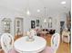 Elegant dining area with chandelier lighting, hardwood floors, and seamlessly opens to living spaces at 13223 Meadowlark Ln, Orlando, FL 32828
