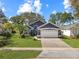 Charming single-story home with a manicured lawn and mature landscaping, painted in pleasing, modern colors at 13223 Meadowlark Ln, Orlando, FL 32828