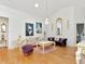 Bright living room featuring elegant white and purple furniture, artwork, and a decorative chandelier at 13223 Meadowlark Ln, Orlando, FL 32828