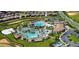 Expansive aerial view of resort-style community pool with cabanas, lounge chairs, and lush landscaping at 1432 Rolling Fairway Dr, Davenport, FL 33896