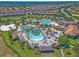 Stunning aerial view of community resort-style pool with palm trees, cabanas, and well-manicured landscaping at 1432 Rolling Fairway Dr, Davenport, FL 33896