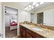 Attached bathroom with granite countertop, double sinks and decorative lighting at 1432 Rolling Fairway Dr, Davenport, FL 33896
