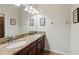 Modern bathroom with double sinks, granite countertops, dark cabinets and decorative lighting at 1432 Rolling Fairway Dr, Davenport, FL 33896