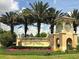 The ChampionsGate entrance showcases lush landscaping, a stone sign, and beautiful architectural details for a welcoming atmosphere at 1432 Rolling Fairway Dr, Davenport, FL 33896