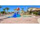 ' pool with a splash zone and colorful water features with lounge chairs and community buildings in the background at 1432 Rolling Fairway Dr, Davenport, FL 33896
