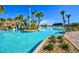 Gorgeous pool area with water slide, palm trees, lounge area and clear blue water for luxurious outdoor living at 1432 Rolling Fairway Dr, Davenport, FL 33896