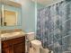 Bathroom features include a granite-topped vanity and shower with stylish blue patterned curtain at 1459 Rylee Rock Way, Kissimmee, FL 34744