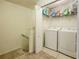 Laundry room featuring full-size washer, dryer, shelving and tiled flooring near carpeted stairs at 1459 Rylee Rock Way, Kissimmee, FL 34744