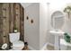Charming powder room with a pedestal sink, round mirror, and decorative wooden wall at 204 Taft Dr, Davenport, FL 33837